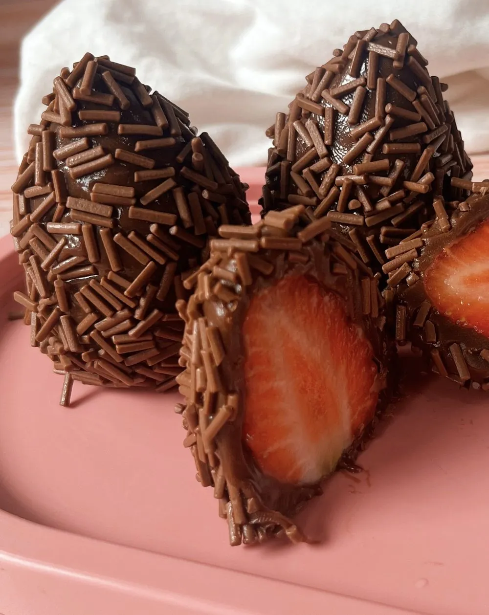 Coxinha de morango com chocolate: Morango inteiro envolvido em brigadeiro de chocolate