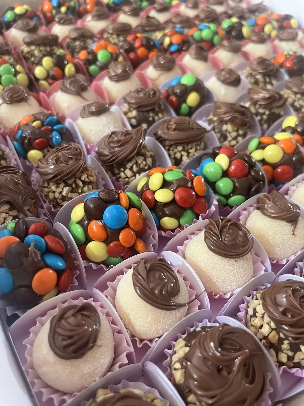 Bandeja de docinhos de festa com confeitos coloridos, castanha e Nutella