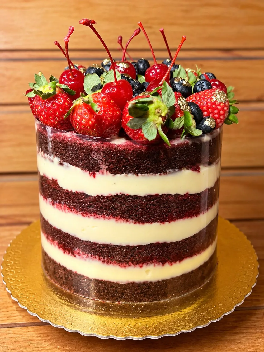 Naked cake red velvet com recheio branco, coberto de morangos, cerejas e mirtilos